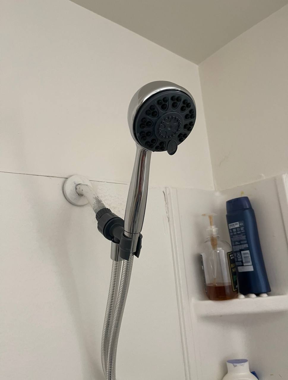 Handheld showerhead on a wall bracket with a flexible hose