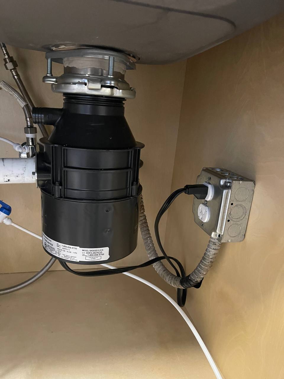Garbage disposal and drain connections beneath a sink
